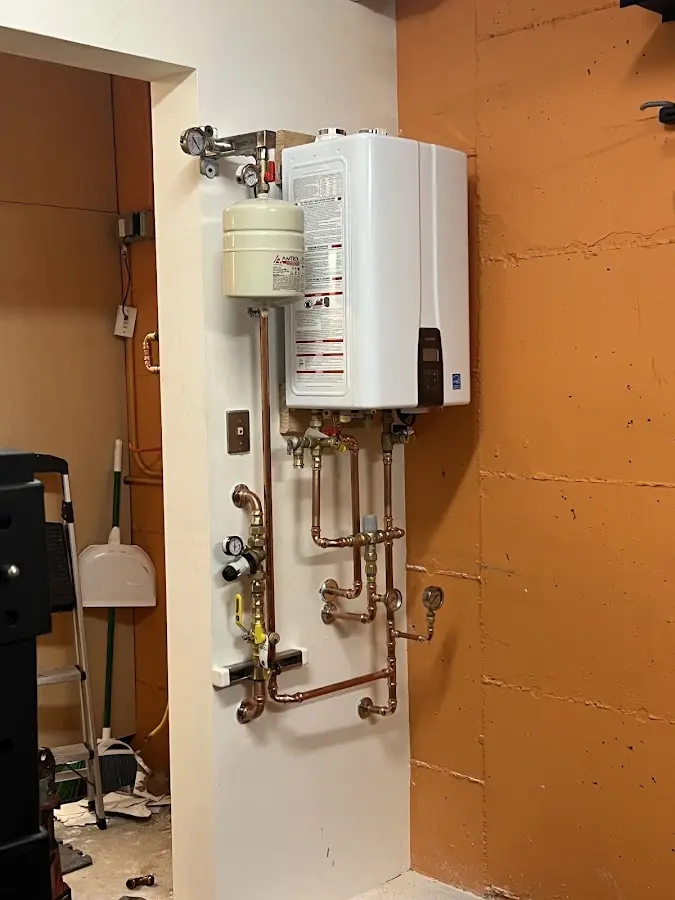 Plumbing technician inspecting water heater connections in Lake Shore